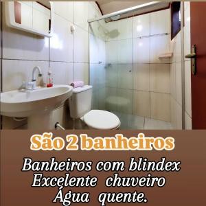 a bathroom with a toilet and a sink and a shower at Refúgio da Colina Lumiar 3quartos 2banheiros 10pessoas in Nova Friburgo