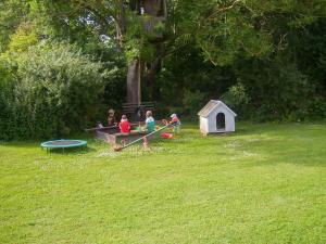 un groupe d'enfants jouant dans un parc dans l'établissement Ferienwohnungen am Waldrand, à Ahrenshagen