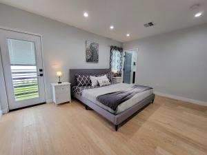 ein Schlafzimmer mit großem Bett und Fenster in der Unterkunft Modern luxury 3 bedroom home next to La Cienega Plaza with parking, WiFi, TV, BBQ 10 minutes to Rodeo Drive in Los Angeles