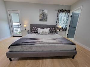 ein Schlafzimmer mit einem großen Bett und zwei Spiegeln in der Unterkunft Modern luxury 3 bedroom home next to La Cienega Plaza with parking, WiFi, TV, BBQ 10 minutes to Rodeo Drive in Los Angeles