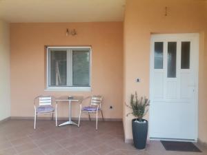 a patio with two chairs and a table and a window at Apartman EMANA in Veternik
