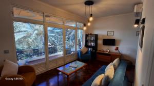 a living room with a blue couch and a large window at Vila Calaça in Funchal