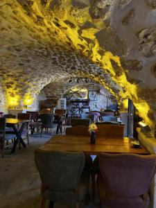 a dining room with a wooden table and chairs at Mons Masius Hotel Teras in Midyat