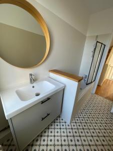 a bathroom with a white sink and a mirror at Maison Paris La Défense in Asnières-sur-Seine