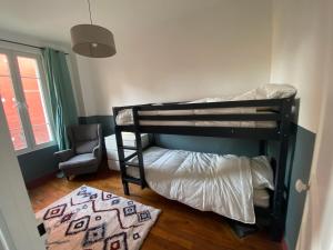 a bedroom with two bunk beds and a chair at Maison Paris La Défense in Asnières-sur-Seine