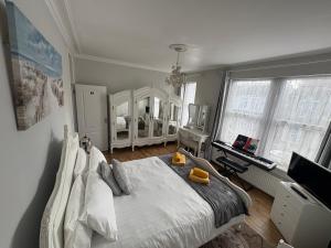 a bedroom with a large white bed and a desk at Sami in Southend-on-Sea