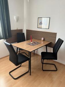 a wooden table with two black chairs and a table with at Haus Marisa Ferienwohnungen in Aflenz Kurort +1 photo