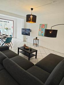 a living room with a couch and a table at Exklusives Apartment in Geilenkirchen für 6 Personen mit Dachterasse und Wintergarten in Geilenkirchen