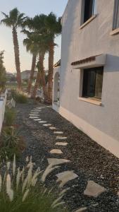 Un camino de piedra junto a un edificio con palmeras. en Perle Di Gio, en Lárnaca