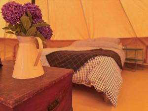 a vase with purple flowers sitting on a table at Boscoppa Farm-Furnished Bell Tent 4 in St Austell