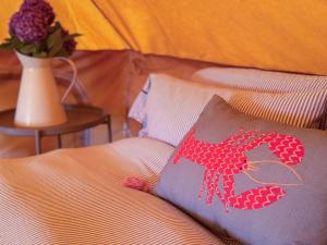 a bed with a pillow with a red lobster on it at Boscoppa Farm-Furnished Bell Tent 4 in St Austell