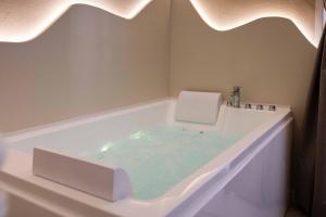a bathroom with a tub filled with blue water at Dharma Luxury Room in La Spezia