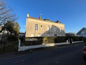 a large house with a fence on the side of a street at L 'Émeraude, appt avec terrasse proche de la plage in Asnelles