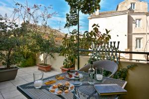 a table with a plate of fruit on a balcony at CASA VERDE in Corfu Town