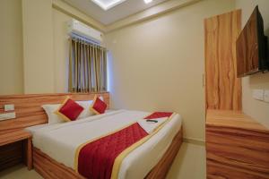 a bedroom with a large bed with red pillows at Yaad Inn in Cochin