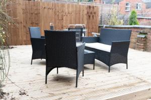 eine Gruppe von Stühlen und ein Tisch auf einer Terrasse in der Unterkunft Spacious 5 Bedroom Gem Near Town Center, WiFi, Smart TVs, 2 Shower Rooms in Northampton