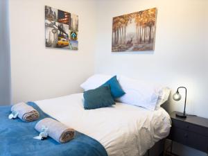 ein Schlafzimmer mit einem Bett mit Handtüchern darauf in der Unterkunft Spacious 5 Bedroom Gem Near Town Center, WiFi, Smart TVs, 2 Shower Rooms in Northampton