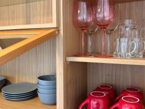 a cupboard with wine glasses and plates and bowls at View-HongDae in Seoul +13 photos