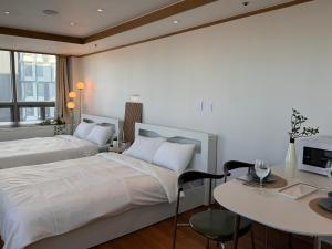 a bedroom with two beds and a table and a desk at View-HongDae in Seoul