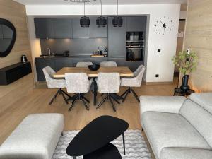 una cucina e un soggiorno con tavolo e sedie di Apartment 70 m2 - 3 rooms - 6 people - ski-in ski-out a LʼAlpe-dʼHuez