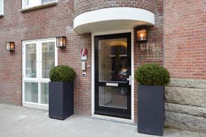 a entrance to a brick building with two potted plants at The Muse Amsterdam - Boutique Hotel in Amsterdam