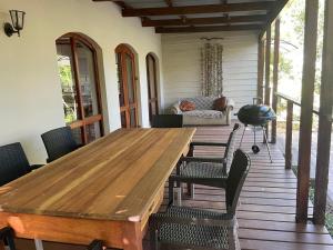 a wooden table on a porch with chairs and a couch at This Is Us in Franschhoek +13 photos