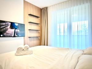 a bedroom with a bed with a tv and towels at 4FriendsBrasov K34 in Braşov