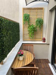 une table et des chaises en bois sur une terrasse ornée de plantes dans l'établissement Orfeas Suite, à Ioannina