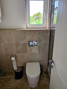 a small bathroom with a toilet and a window at Belvedere, LaVanta, Kalkan in Kalkan
