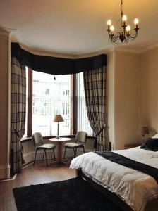 1 dormitorio con 1 cama, mesa y sillas en Hannahs Guesthouse en Aberdeen