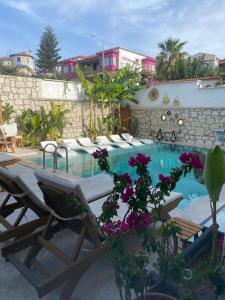 a swimming pool with chaise lounge chairs and flowers at Chloe hotel Alacati in Alacati