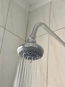 un soffione doccia con acqua che ne esce di Homely Lodge And Apartments a Lilongwe