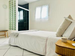 Un dormitorio blanco con una cama grande y una mesa. en Escapade à Vinon sur Verdon, en Vinon-sur-Verdon