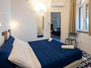 a bedroom with a blue and white bed in a room at Villa Cliff House - Le Sea House in Atrani