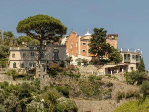 a group of houses on a hill with a tree at Villa Cliff House - Le Sea House in Atrani