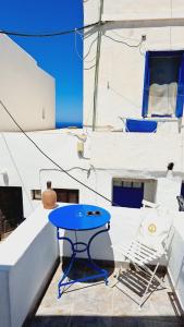 a blue table and a chair on a balcony at Margarita's Rooms in Chora Folegandros +18 photos