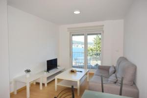 a living room with a couch and a table at Apartamento Playa de Quenxe in Corcubión