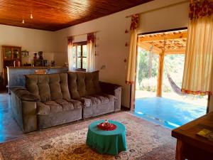a living room with a couch and a table at Casa Alto do Lago - Refúgio de Paz na Mantiqueira in Gonçalves