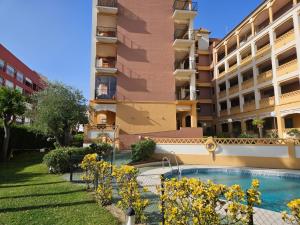 a building with a swimming pool in front of a building at El Paraíso de Isla Canela in Isla Canela