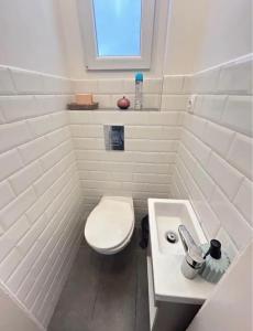 a white bathroom with a toilet and a sink at Leo Heart Rooms in Budapest