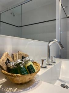 a bathroom sink with a basket of soap and a mirror at Rivadavia Apartment in Buenos Aires