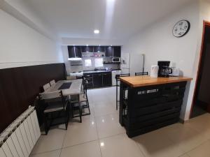 a kitchen with a table and chairs and a clock on the wall at Morada del sur in Ushuaia
