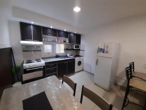 a kitchen with a table and a white refrigerator at Morada del sur in Ushuaia