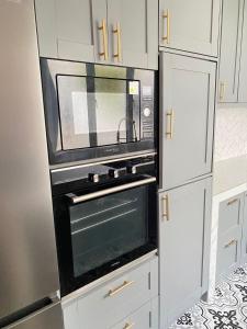 a microwave oven in a kitchen with white cabinets at Tuah Homestay Puncak Alam in Bandar Puncak Alam
