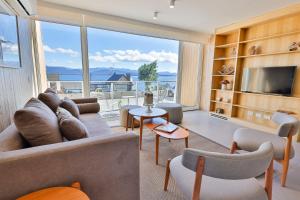 a living room with a couch and a large window at Departamentos Luxe en Bariloche in San Carlos de Bariloche