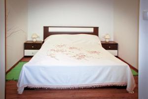 1 dormitorio con 1 cama blanca y 2 mesitas de noche en Garden House, en Matulji