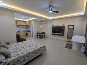 a bedroom with a bed and a tv in a room at Couple Suite Batangas Private Tub and Sunset Balcony in Lobo