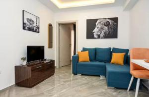a living room with a blue couch and a tv at Portobello in Tivat