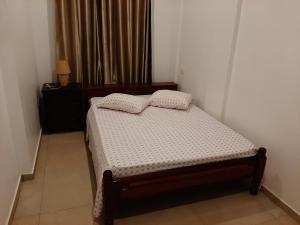 a small bedroom with a bed and a window at Ap ACVA in Mindelo +4 photos