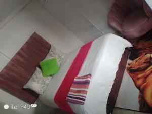 a bed with a colorful blanket and pillows at Tenders Accommodation Rooms Mafikeng in Mahikeng +1 photo